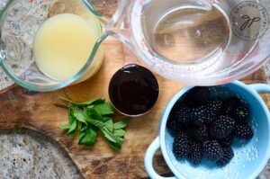 Blackberry Lemonade Recipe ingredients measured and collected on a wood cutting board.