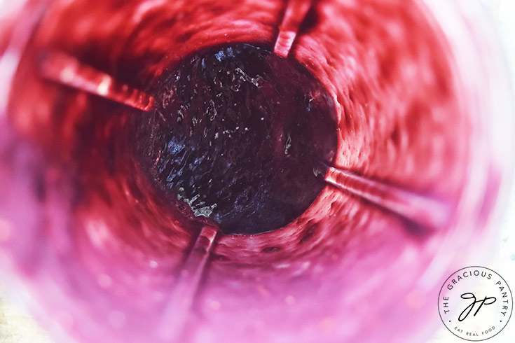 A view of inside a blender tumbler after blending blackberries.