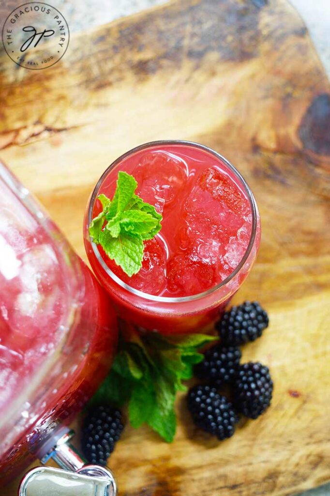 An overhead view looking down into a glass of Blackberry Lemonade with ice and fresh mint leaves.