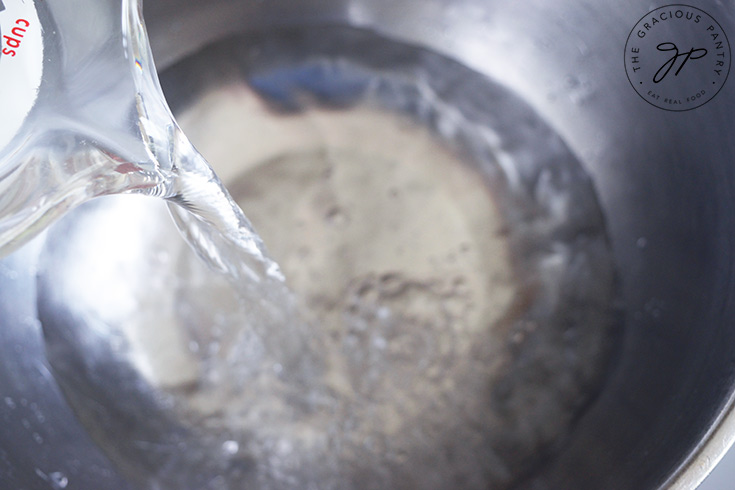 Pouring water into a large mixing bowl.