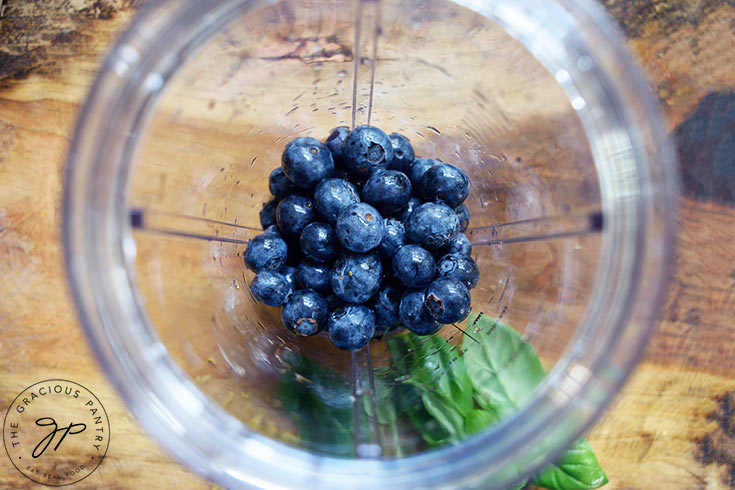 Fresh blueberries sitting in a blender tumbler.