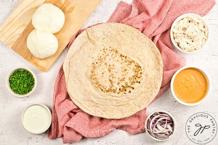 Buffalo Chicken Pizza Recipe ingredients gathered together on a white surface.