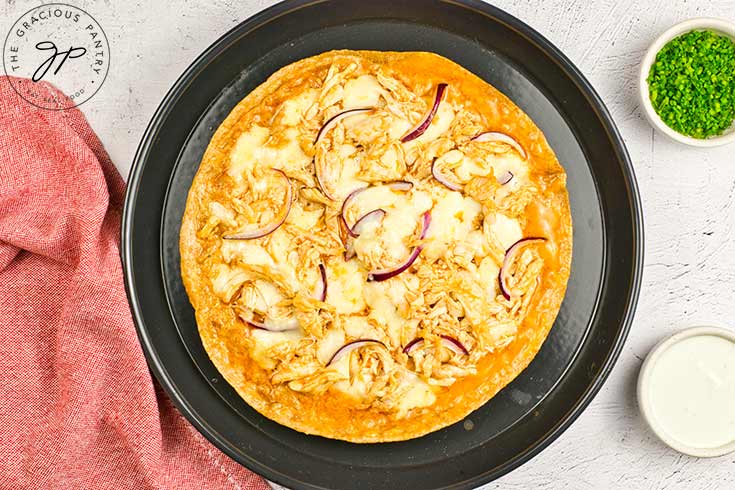 A just-baked Buffalo Chicken Pizza on a pizza pan.