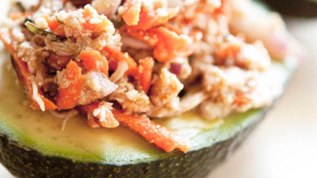 A closeup of an avocado half stuffed with chicken avocado salad.