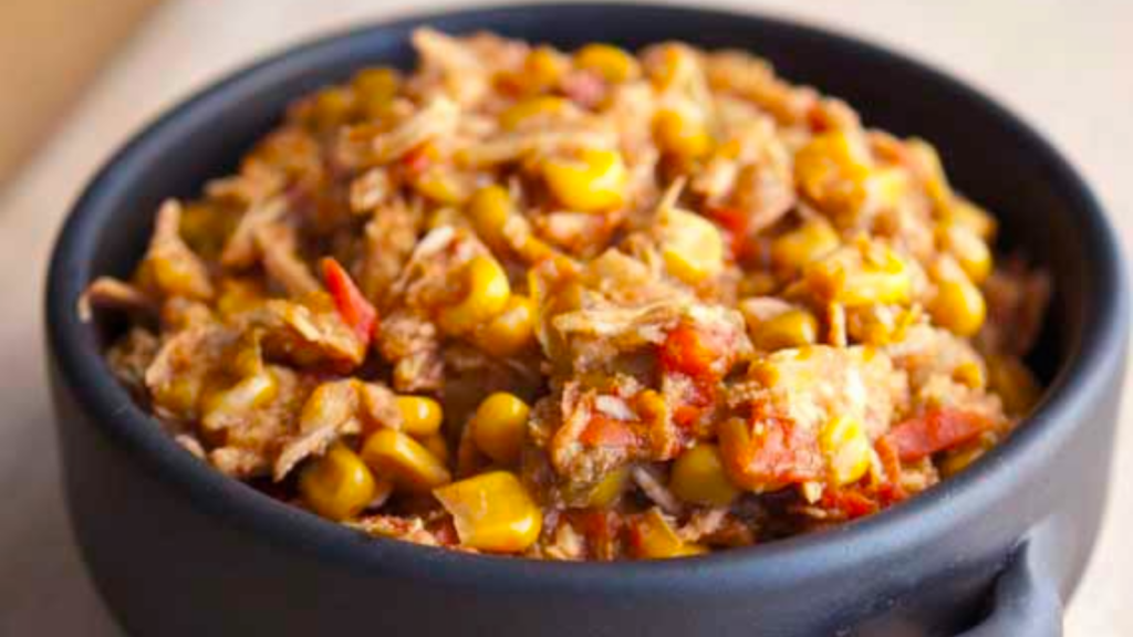 A closeup of a black crock filled with chicken tortilla stew.