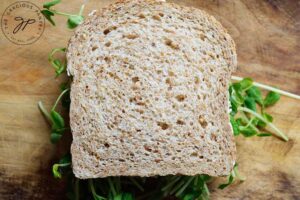 A second slice of bread laid over the microgreens to close the sandwich.