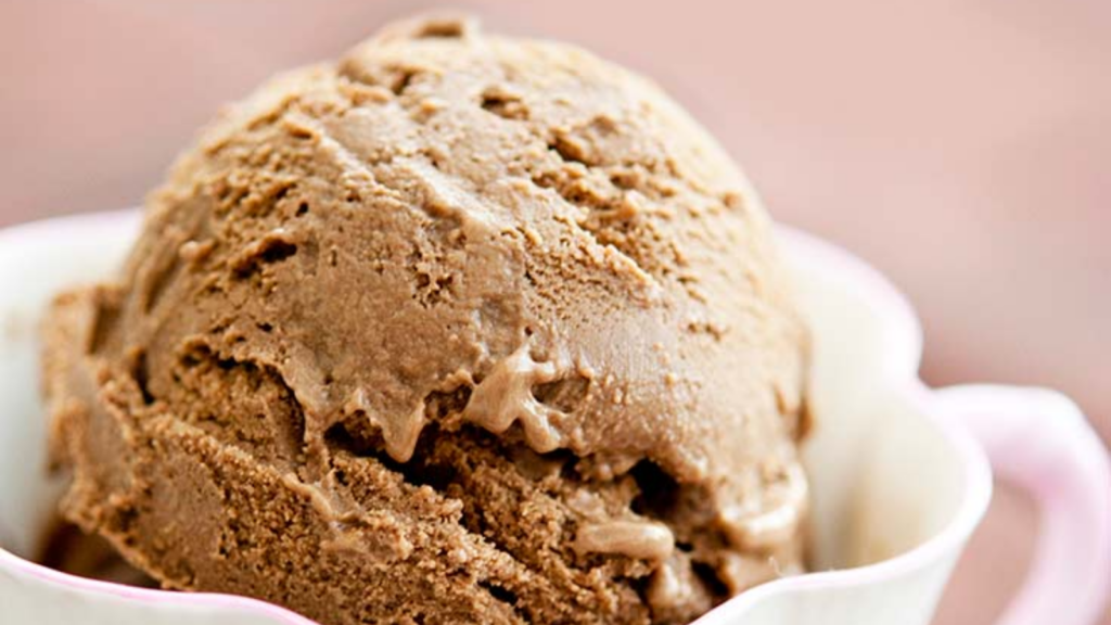 An up close shot of a scoop of diary-free chocolate ice cream in a tea cup.