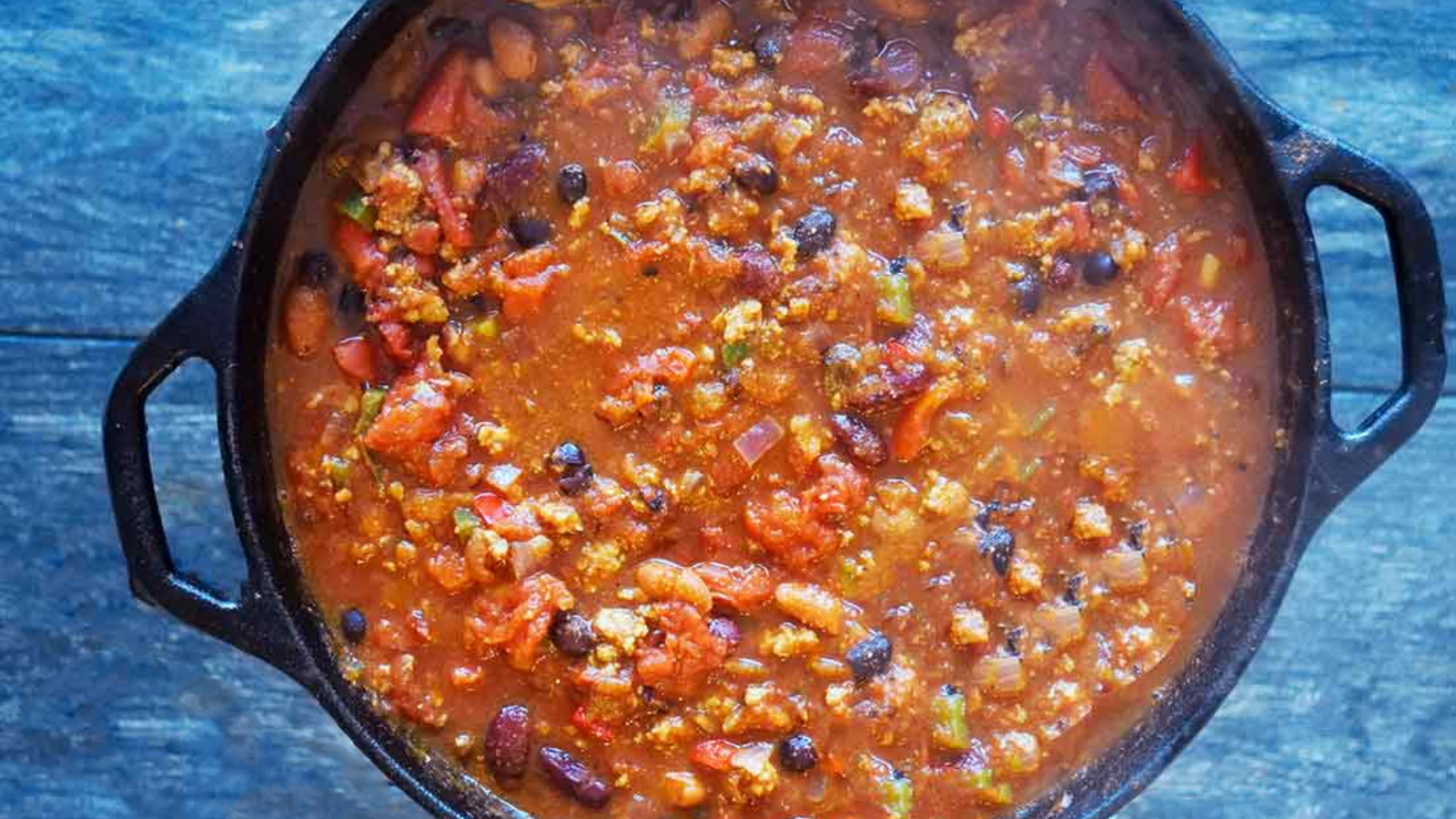 An overhead view of a cast iron dutch oven filled with dutch oven chili.