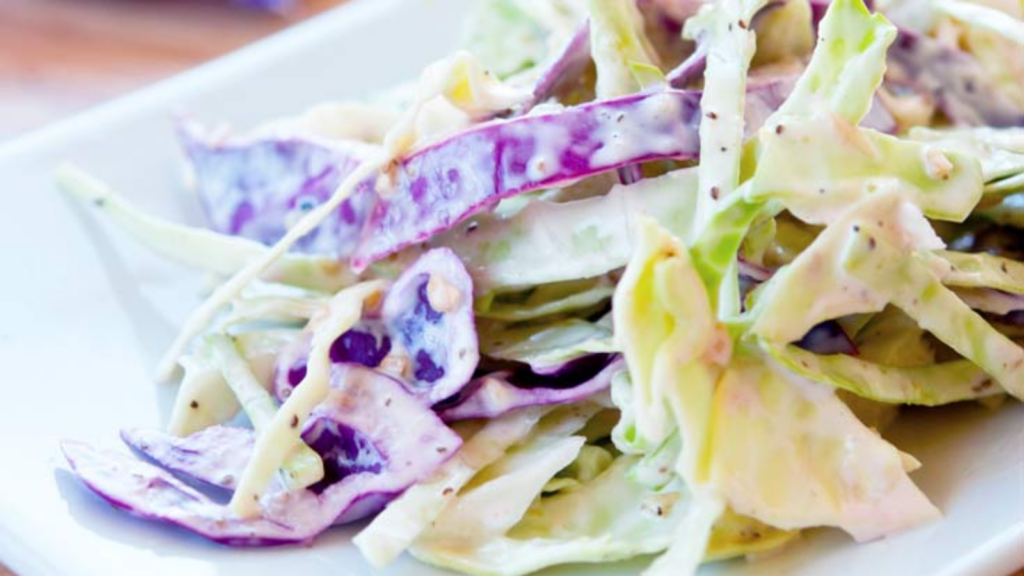 A closeup of homemade, easy coleslaw on a white plate.