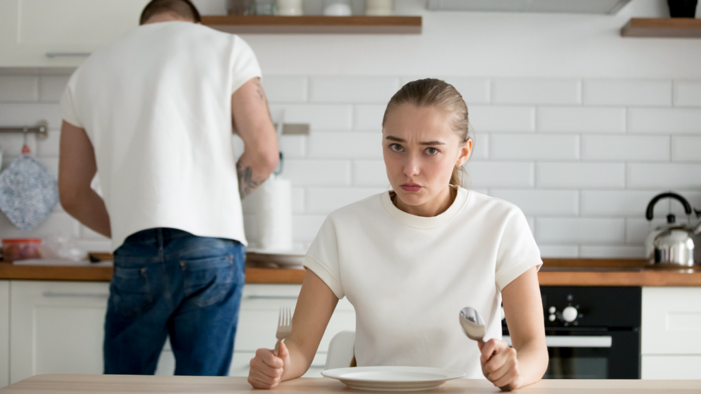 A frustrated woman at a dinner table.