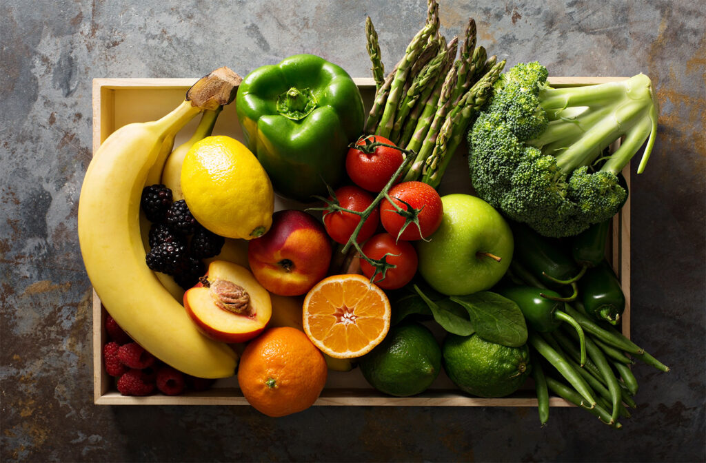 A wooden box filled with fruits and vegetables.