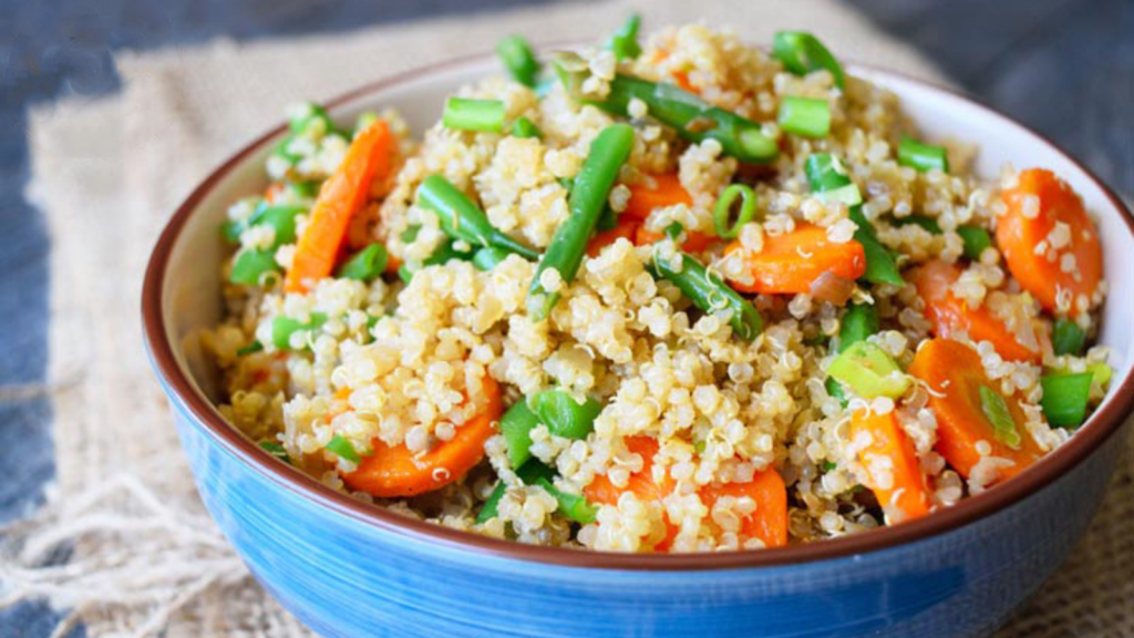 A blue bowl filled with green bean quinoa.