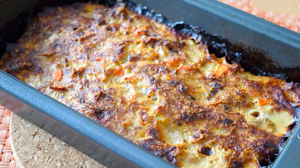 A loaf pan filled with just-baked ground turkey meatloaf.