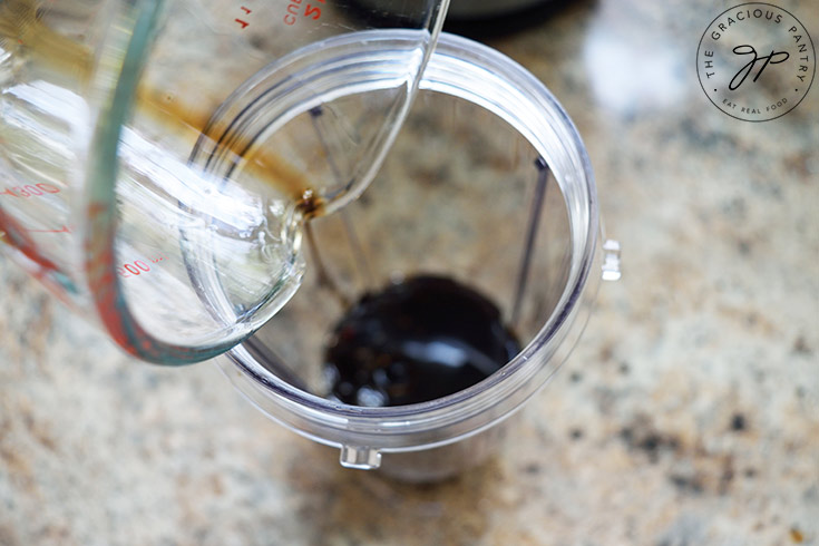 Pouring oil into a blender tumbler.