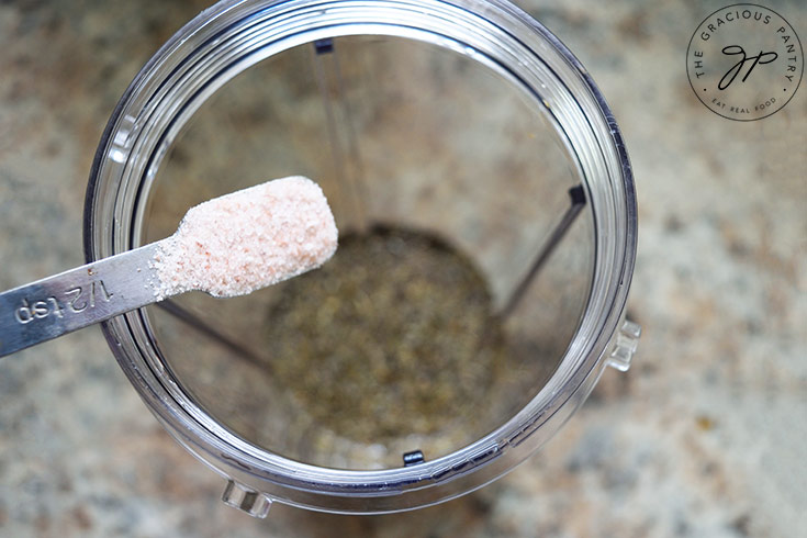 Adding salt to a blender tumbler.