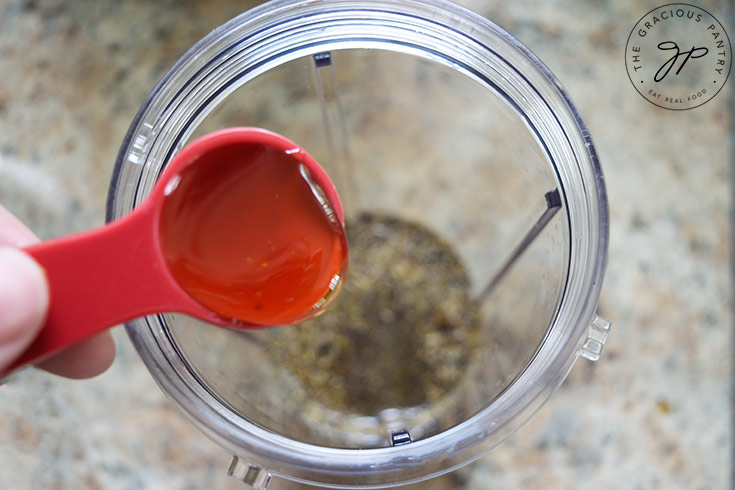 Adding honey to a blender tumbler.