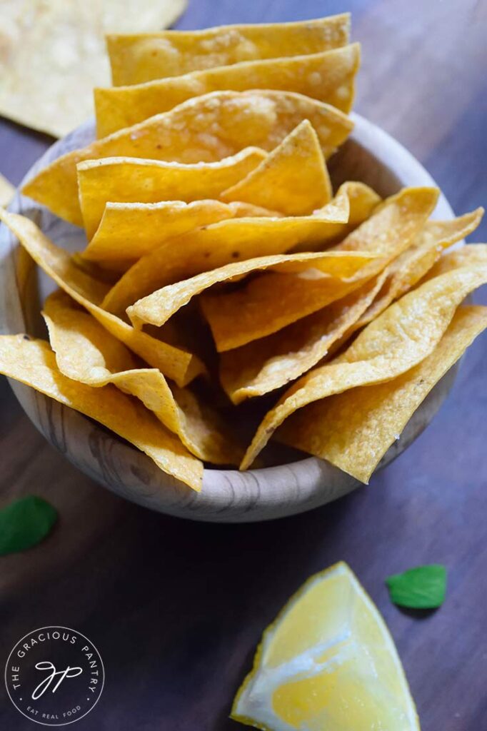 An up close overhead view of a wood bowl filled with Homemade Corn Chips.