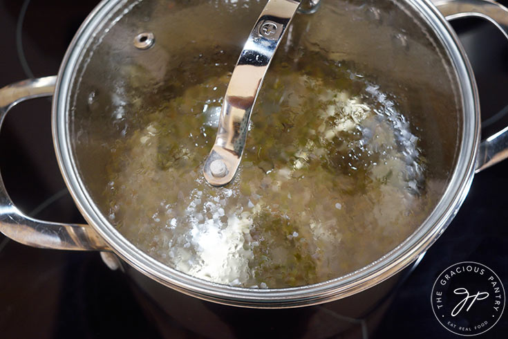 Lavender flowers steeping in hot water in a pot with a lid on.