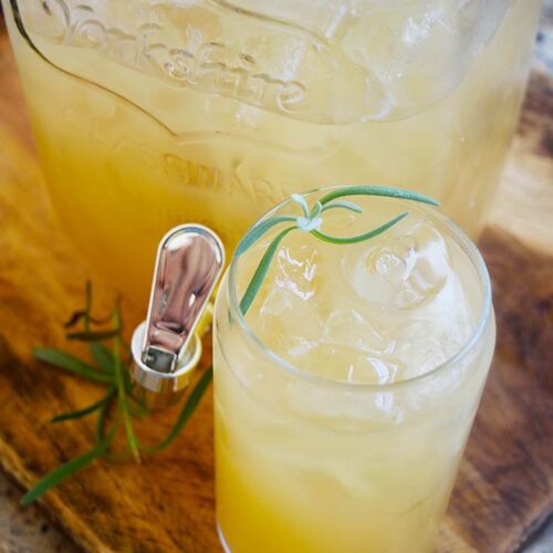 A glass of Lavender Lemonade garnished with fresh lavender.