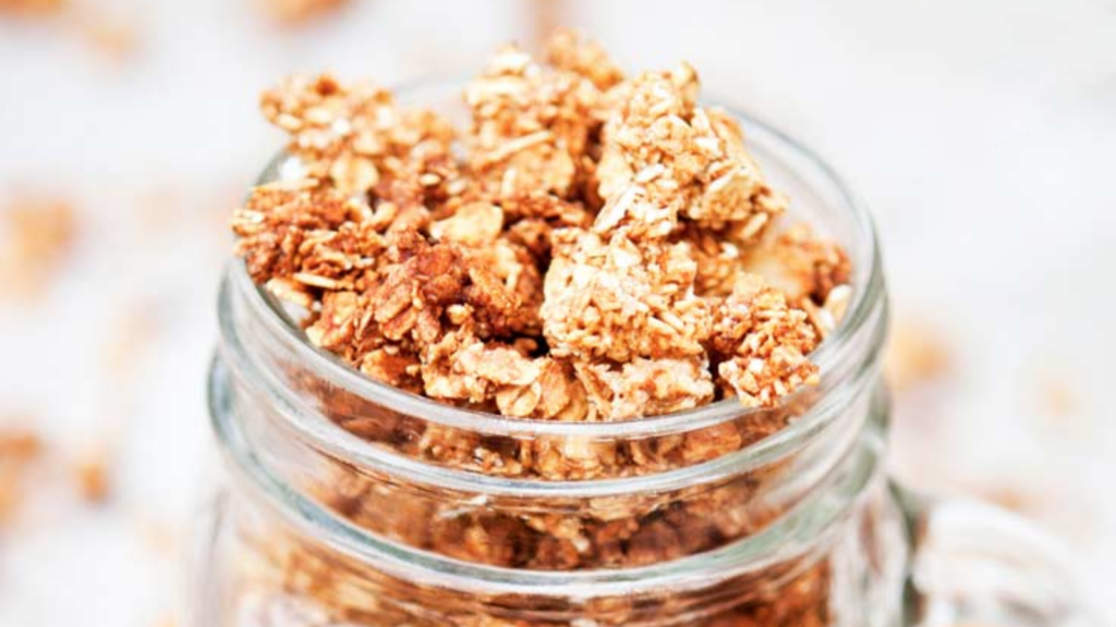 A closeup of an open canning jar filled with maple cinnamon granola.