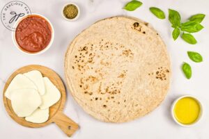 Margherita Pizza Recipe ingredients gathered on a white surface.