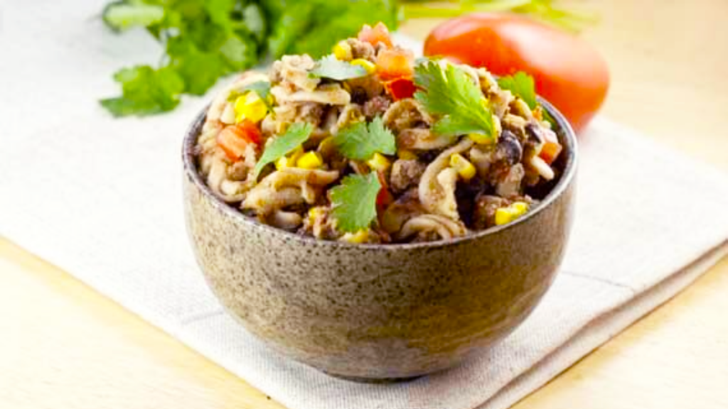 A ceramic bowl filled with Mexican-style chili mac.