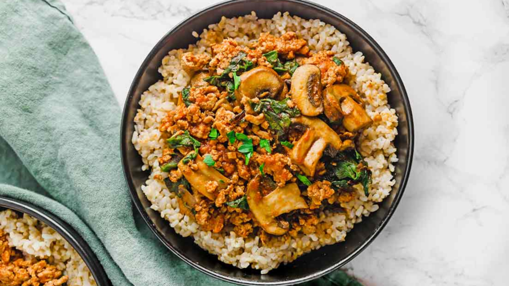 An overhead view of a black bowl filled with this mushroom and brown rice bowl recipe.