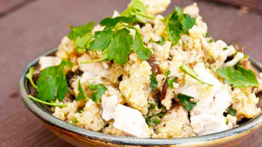 A closeup of a ceramic bowl filled with mushroom quinoa.