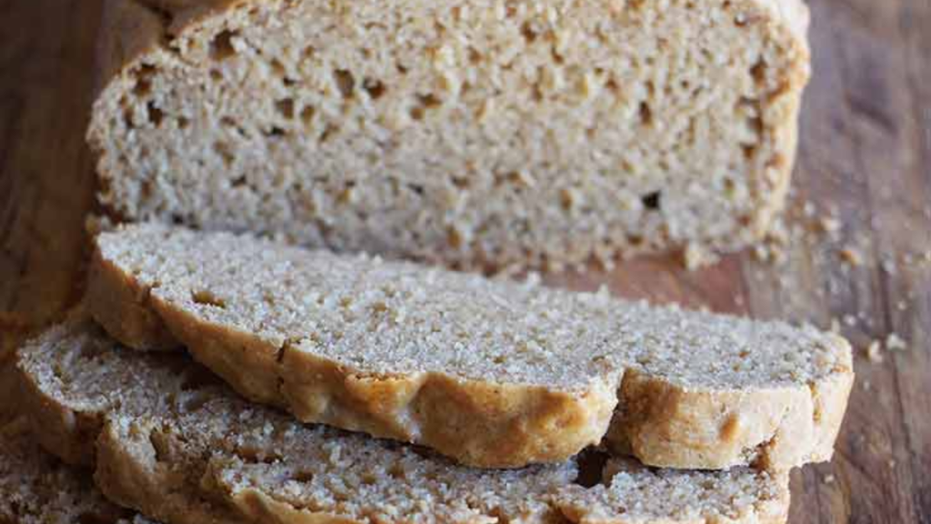 Slices of peanut butter bread cut from a loaf that sits behind them.