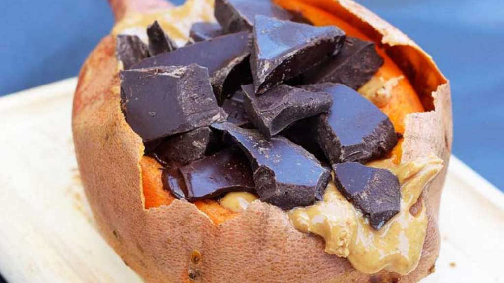 A closeup of a baked sweet potato stuffed with peanut butter and chocolate chunks.