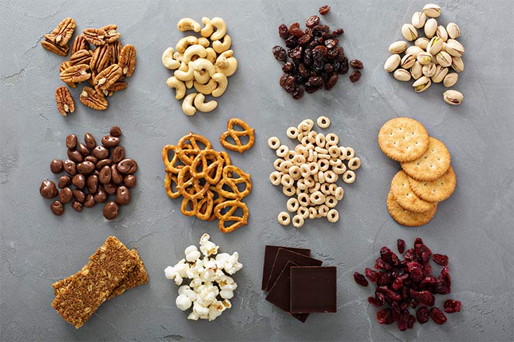 Small portions of various snacks on a gray background.