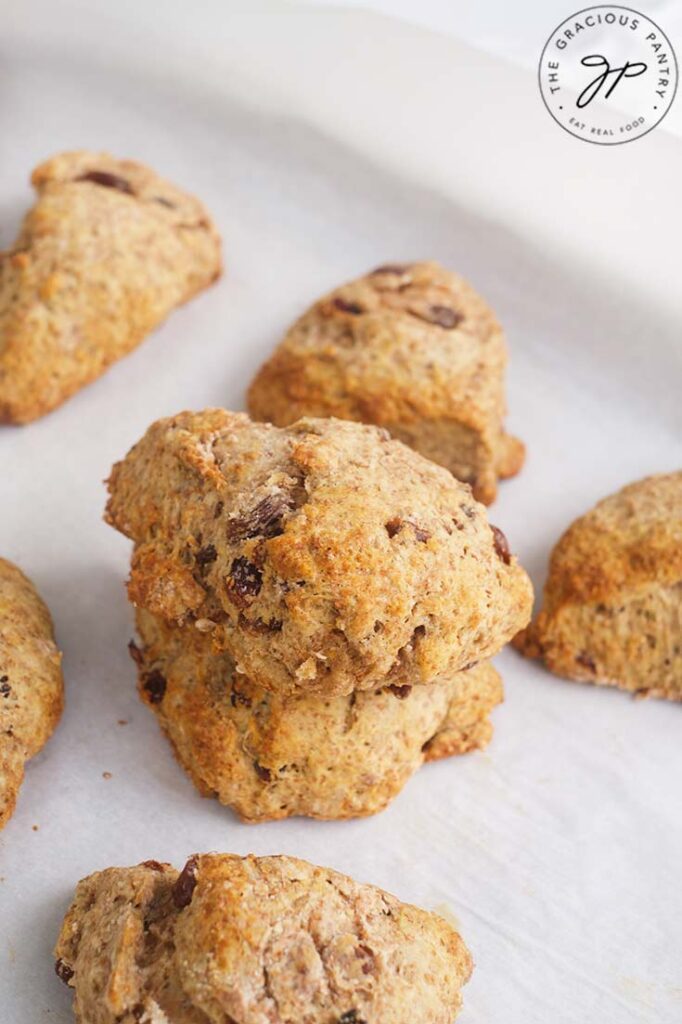 Raisin Scones on a baking pan with two of the scones stacked.