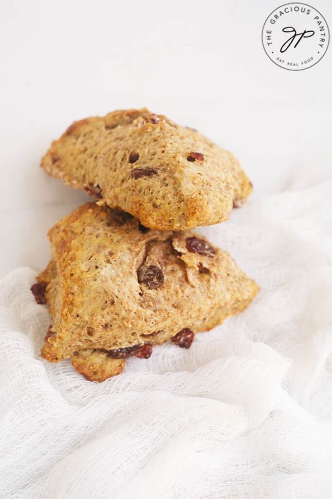 Two Raisin Scones stacked on a white background.