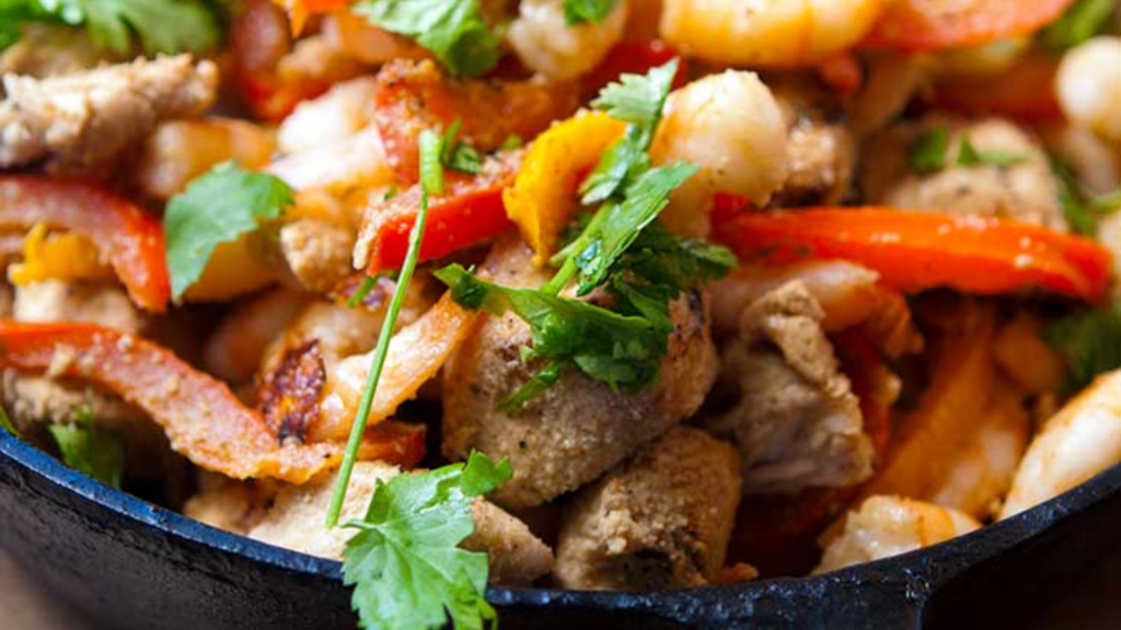 A closeup of this barbecued shrimp and chicken skillet.