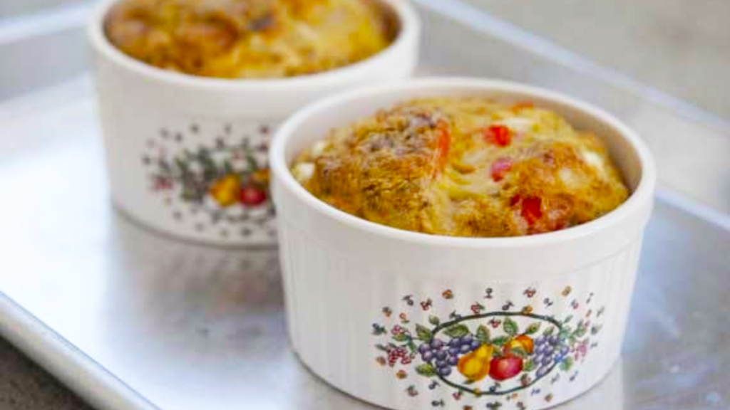 Two small ramekins sit on a baking sheet. They are filled with southwestern crustless quiche.