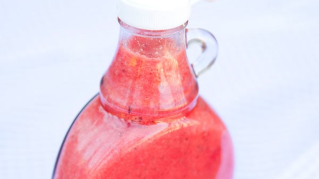 A closeup of a bottle of strawberry vinaigrette.