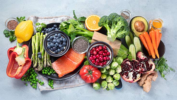 An array of superfoods arranged on a gray background.