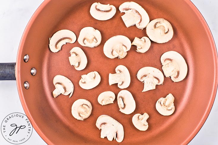 Raw mushrooms in a skillet.