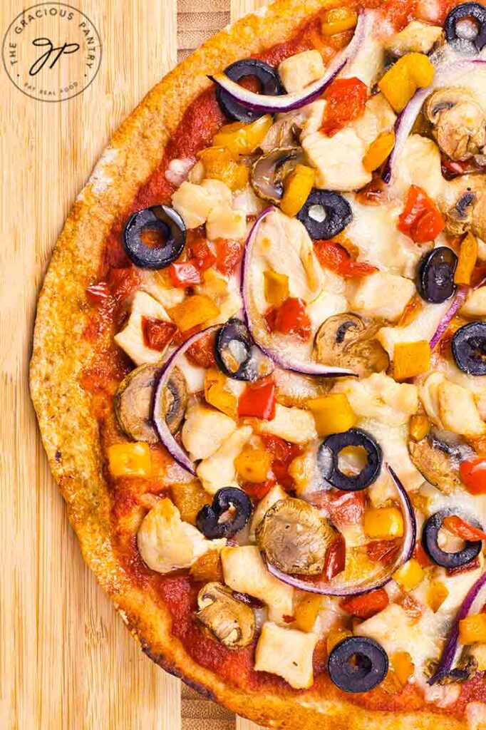 Looking down on a Supreme Pizza laying on a cutting board.