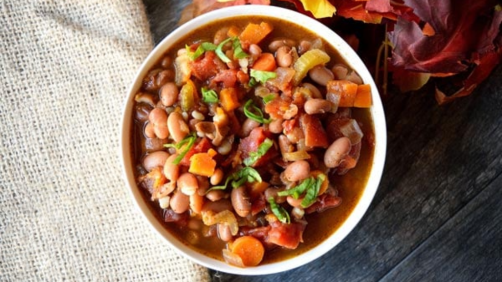 An overhead view of a white bowl filled with sweet potato vegetable chili.