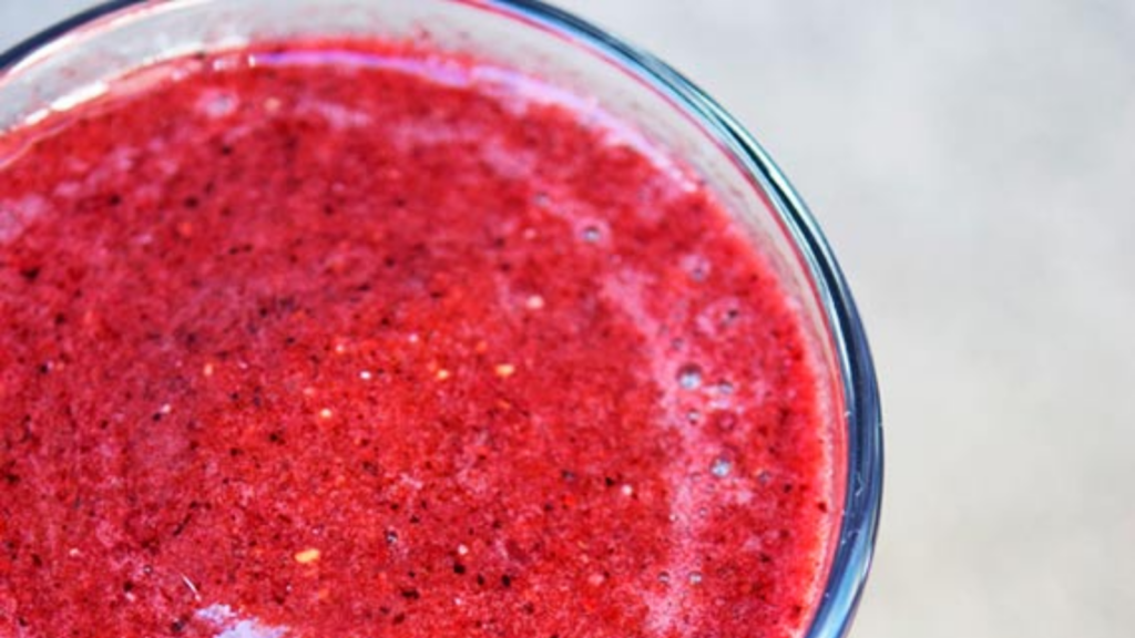 A closeup of a glass filled with triple berry watermelon smoothie.