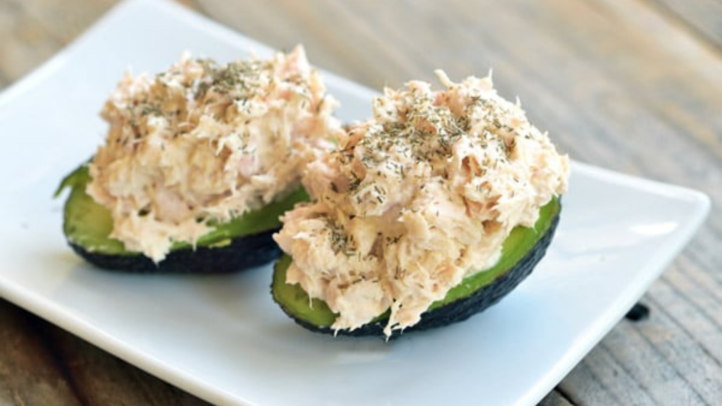 Two avocado halves stuffed with tuna salad.