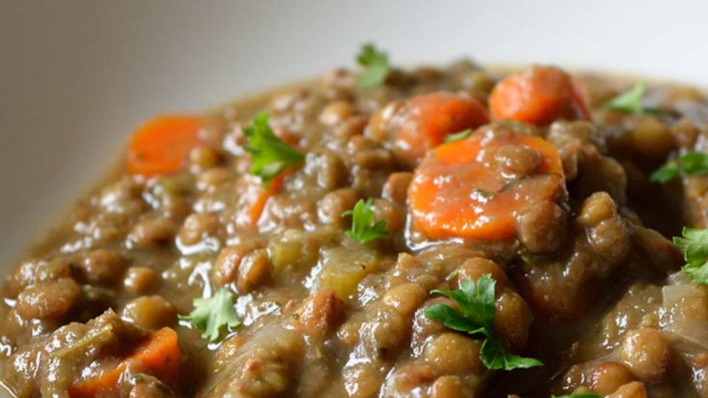 A closeup of a white bowl filled with vegan lentil soup.