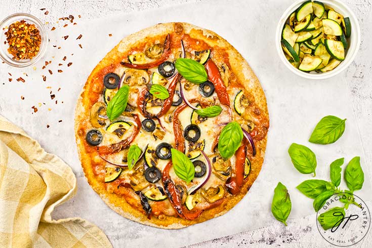 Fresh basil leaves added to the baked pizza.