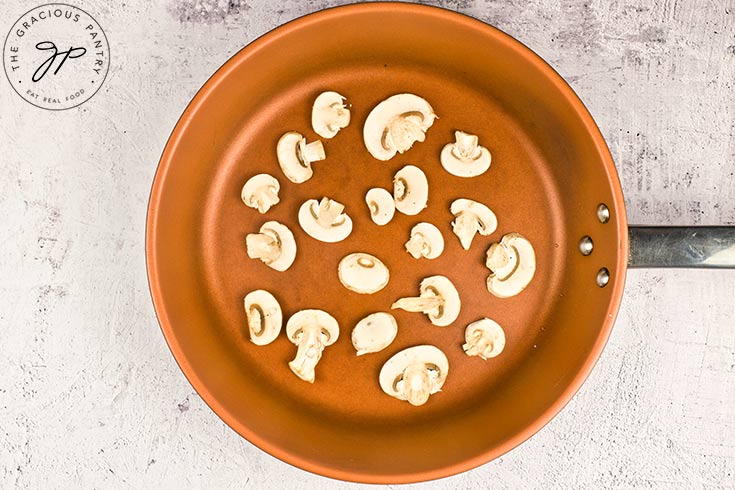 Raw mushrooms in a skillet.