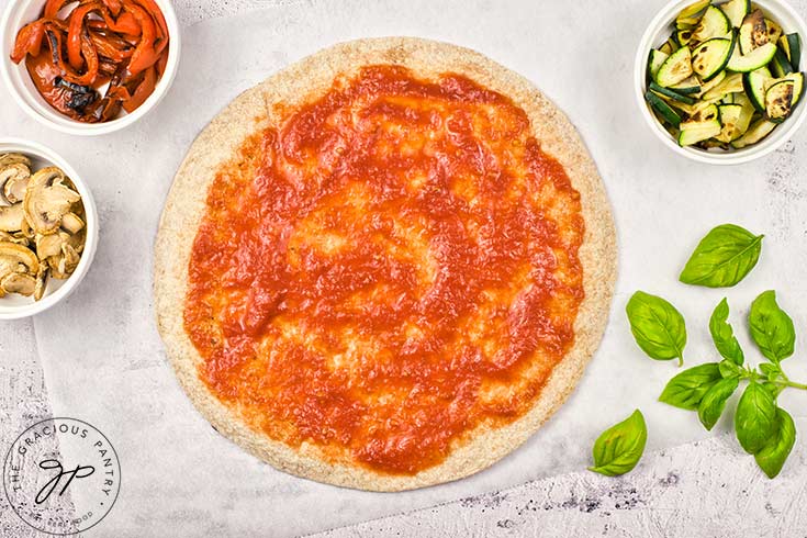 Tomato sauce spread over the pita crust.