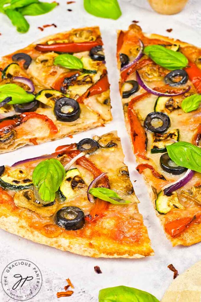 A closeup of a cut veggie pita pizza.