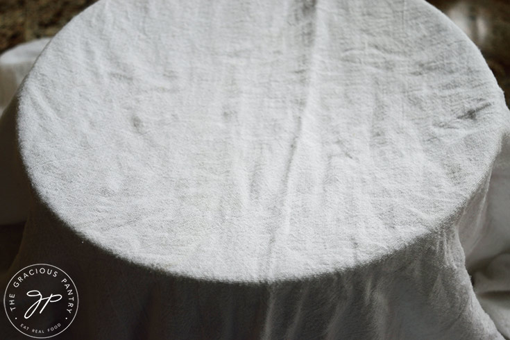 A towel placed over a mixing bowl with dough in it for rising.