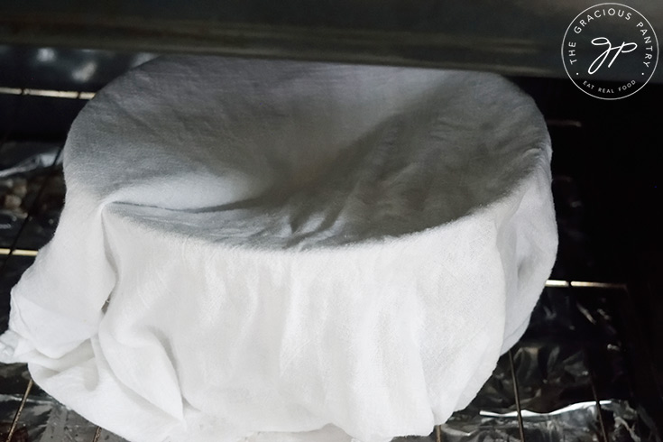 Setting the covered dough bowl in an unheated oven to rise.