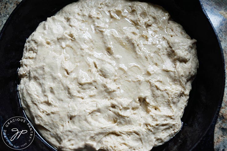 The raw dough with oil drizzled over it.